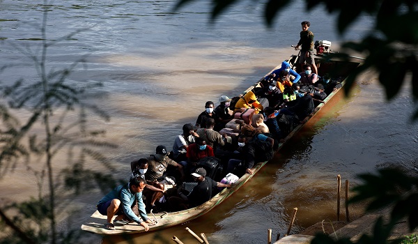Orang ramai dari pelbagai negara, menaiki bot menyeberangi sungai Moei dari Myanmar ke Thailand/ AFP
